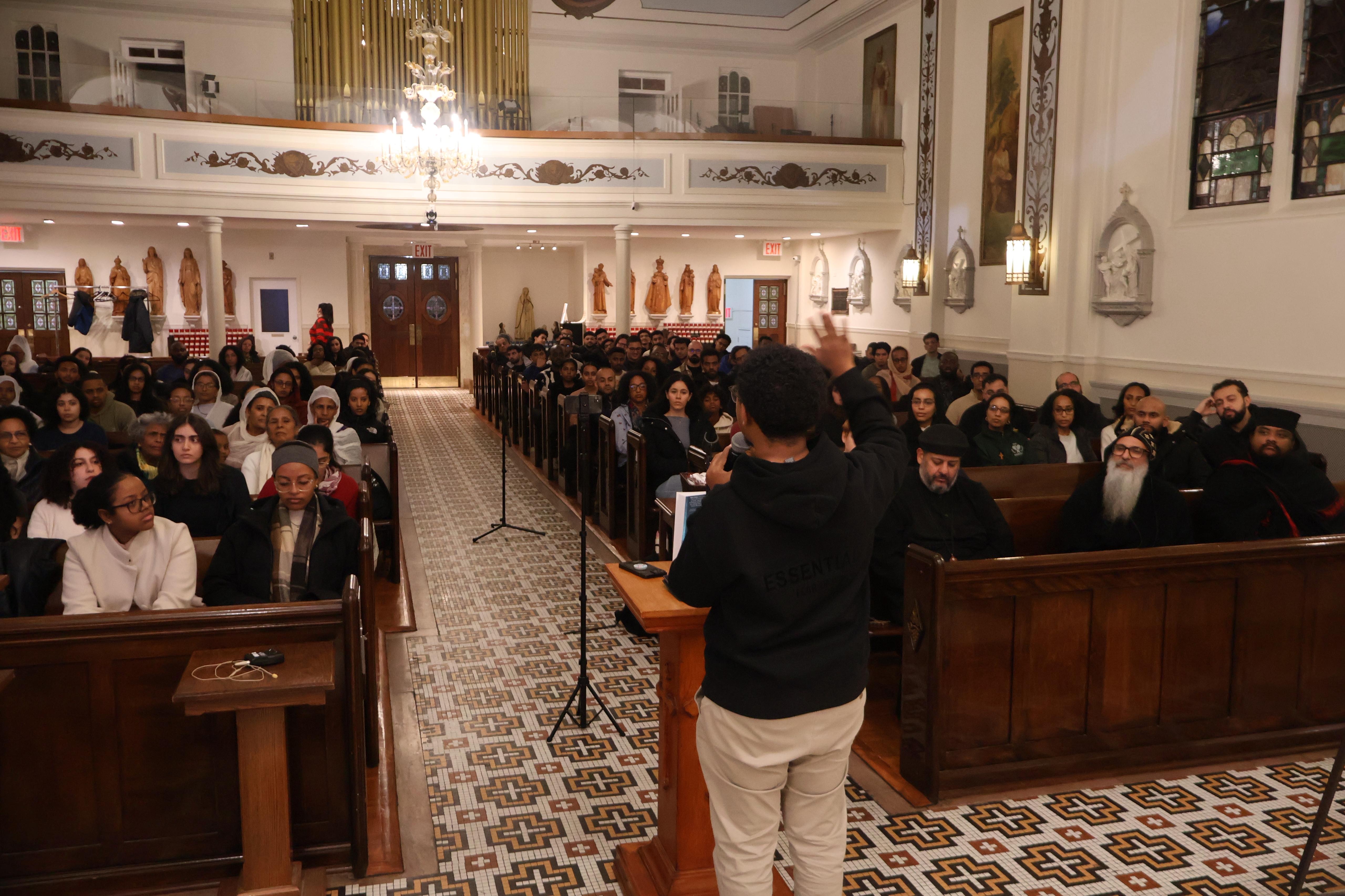 A young speaker addresses the congregation inside the church during an OTY NYC event