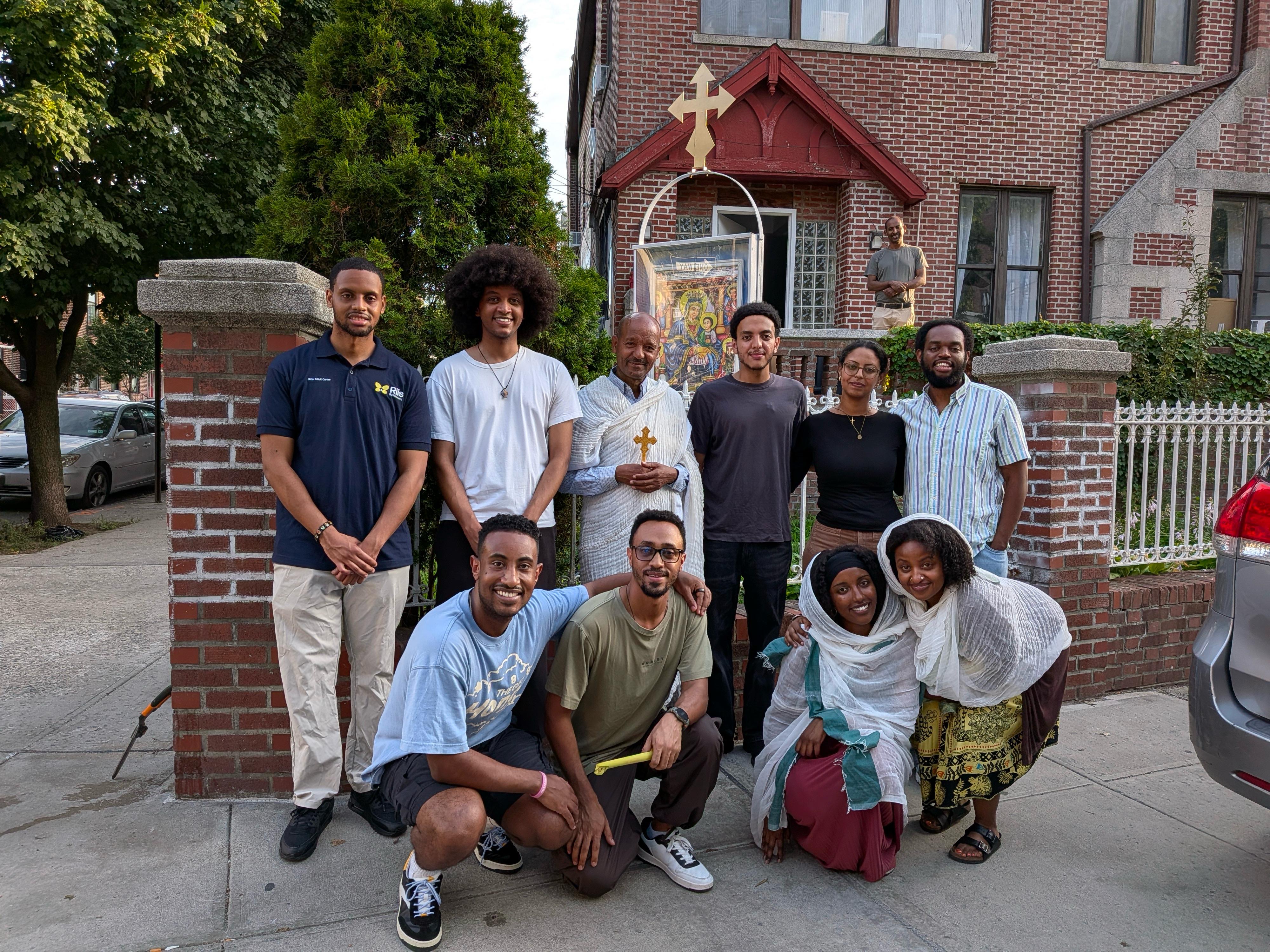 Kesis Ephrem poses with OTY NYC members outside the church